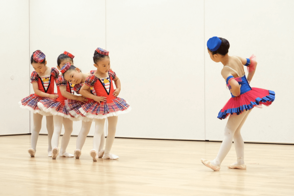 バレエ衣裳を着て踊る幼児たち