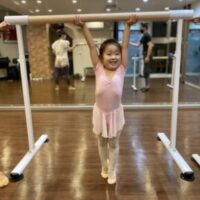 4才の女の子バレエのバーを運ぶ様子
