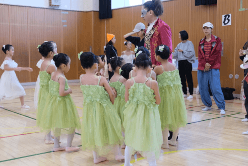 先生に集まるお花のコスチュームを着た幼児たち