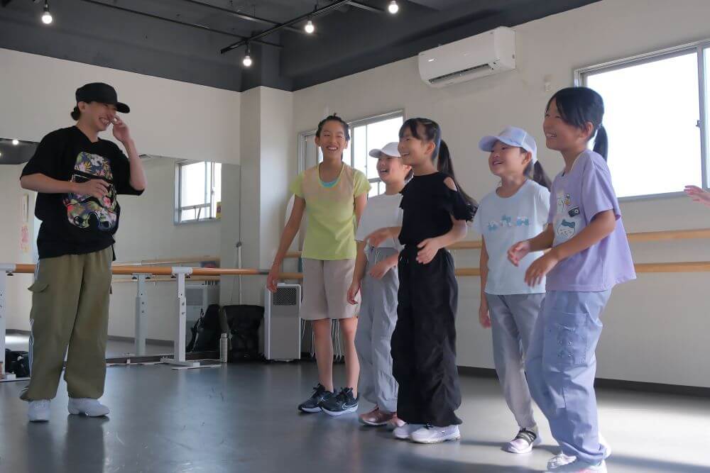 ダンスの先生とお話し中笑顔があふれる小学生たち